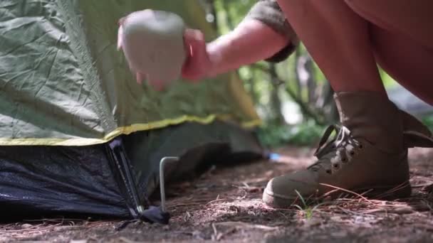 女游客把楔子或钉子钉在地上固定帐篷 — 图库视频影像