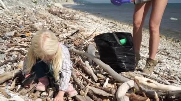 Сім'я з дитиною чисті пластикові відходи і сміття на морському пляжі — стокове відео