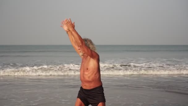 Homme âgé mature, grand-père en bonne santé en bonne forme est la formation sur la plage 
