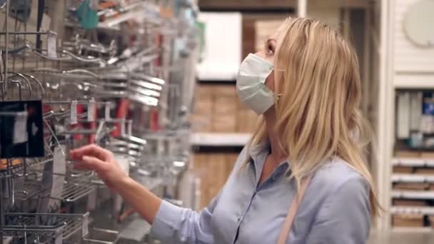 상점이나 슈퍼마켓에서 의료용 마스크를 쓴 채 쇼핑하고 있는 젊은 여자. — 비디오