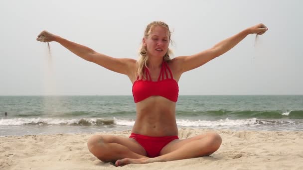 Песок льется из рук женщины на пляже, медленное движение — стоковое видео