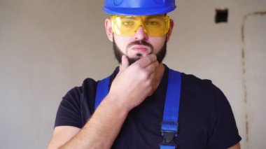 İş üniformalı seksi bir müteahhidin portresi. İnşaat alanında çalışan bir işçi.