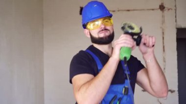 Neşeli erkek müteahhit şantiyede dans ediyor. Mutlu bir işçinin portresi
