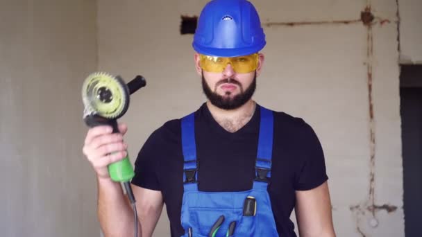 Açı öğütücüsü olan bir inşaatçının portresi. İnşaat alanında çalışan bir işçi. — Stok video