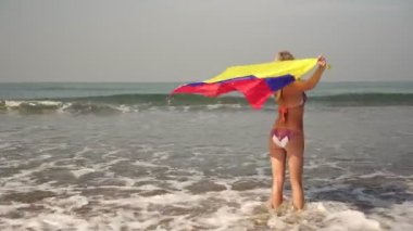 Kolombiya bayrağı taşıyan bir kadın. Plajda Kolombiya bayrağı taşıyan bir kız.