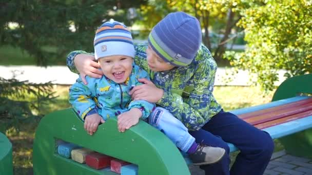 Kinderen veel plezier met het spelen op de Bank in het Park — Stockvideo