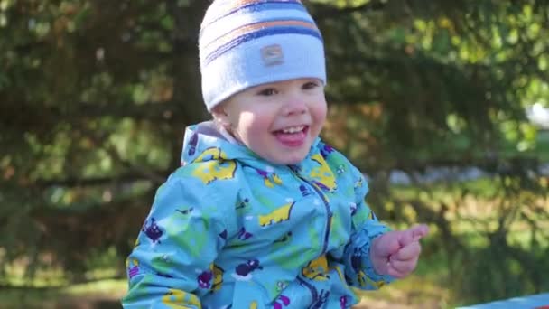 Baby lachen in het Park zitten op de Bank — Stockvideo