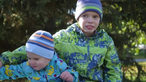 Niños se divierten jugando en el banco en el Parque — Vídeos de Stock