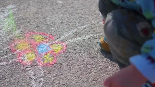 Niño dibuja con tiza en el pavimento — Vídeos de Stock