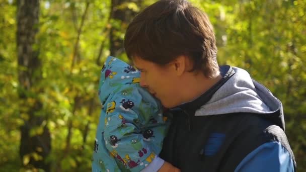 Jovem pai brincando ternamente com o bebê no outono Parque close-up — Vídeo de Stock