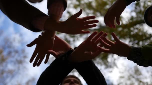 Group of young place their hands together in the center of a circle — Stock Video