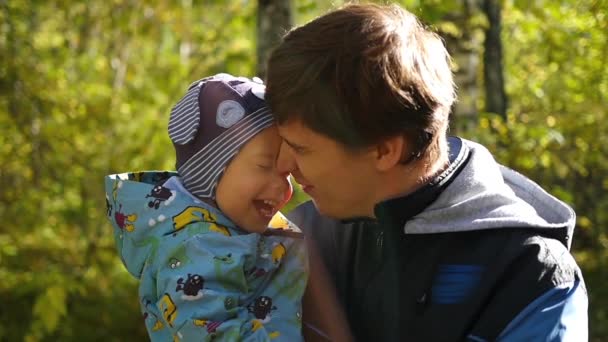 Young father tenderly playing with baby in the autumn Park closeup — Stock Video