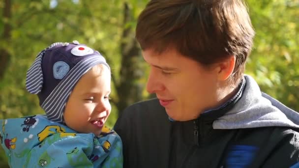 Young father tenderly playing with baby in the autumn Park closeup — Stock Video