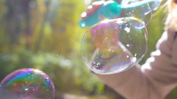 Meisje waait grote zeepbellen close-up in zonlicht — Stockvideo