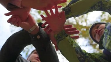 Grup genç yer ellerini birlikte bir daire ortasında
