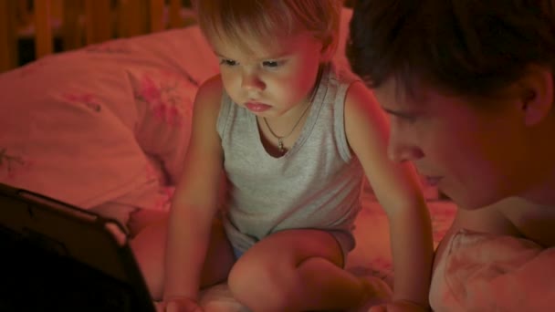 El niño pequeño con el padre que mira los dibujos animados en la tableta por la tarde — Vídeo de stock