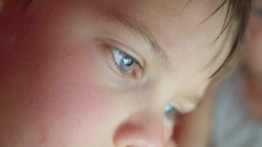 Oğlum battaniyenin altında yalan ve çizgi film izlerken pad closeup yüz touch