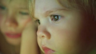 battaniyenin altında yalan ve çizgi film izlerken çocuklar pad closeup yüz dokunma