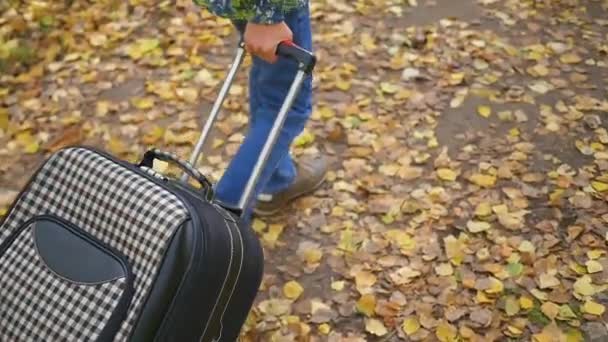 Tiener met koffer lopen op de stoep — Stockvideo
