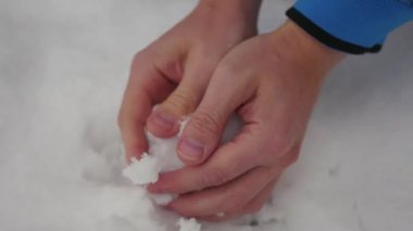 Çocuk bir kartopu çıplak elle sculpts