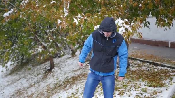 Tipo lanza una bola de nieve en el parque de otoño — Vídeos de Stock