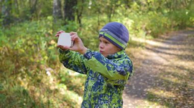 Çocuk bir selfie sonbahar Park yapar.