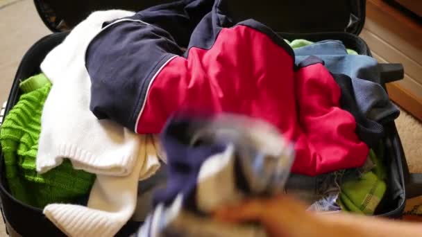 Женщина кладет вещи в чемодан — стоковое видео