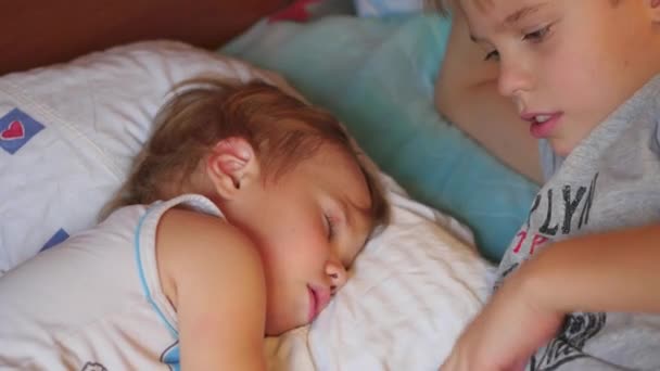 El hermano mayor acarició suavemente al hermano pequeño dormido en casa — Vídeo de stock