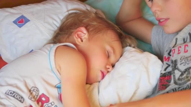 El hermano mayor besó suavemente al hermano menor durmiendo en casa — Vídeos de Stock