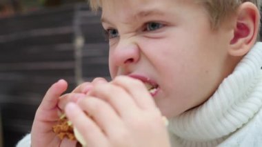 Çocuk bir fast food restoran tatlı bir sandviçi yiyor