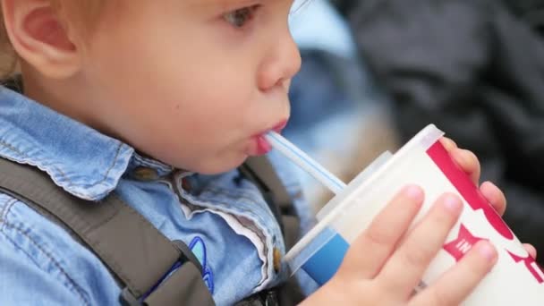 A child drinks from a straw carbonated drink closeup — Αρχείο Βίντεο