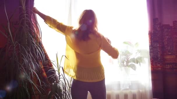 La chica abre las cortinas y bailando a la luz del sol — Vídeos de Stock