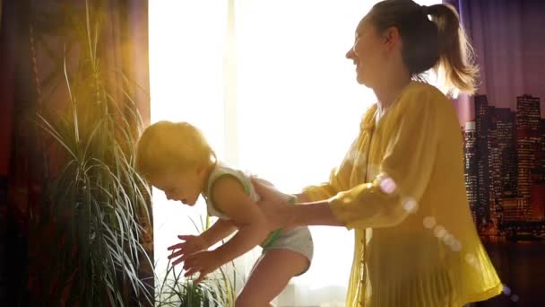 Девочка с ребенком танцует под солнечным светом — стоковое видео