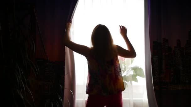 The girl opens the curtains and dancing in the sunlight — ストック動画