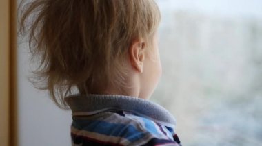 bir çocuk kar yağışı evde pencereden görünüyor