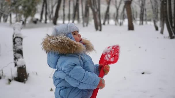 Ребенок ловит снежинки рот в медленном темпе — стоковое видео
