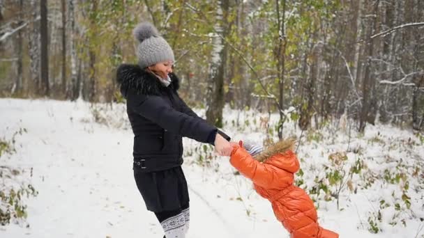 Madre girando niño en invierno Parque — Vídeos de Stock