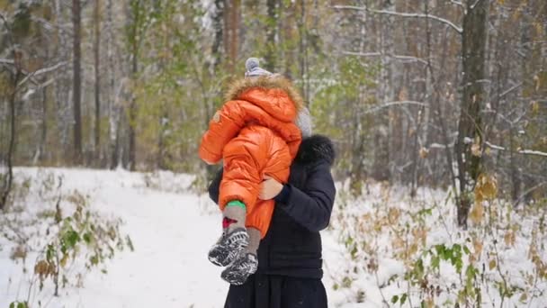 Мама играет с ребенком в зимнем парке — стоковое видео