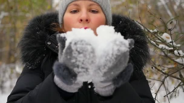 Girl blows snow with hands closeup in slowmo — Stock Video