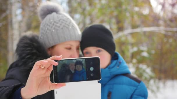 Lykkelig familie gør en selfie om vinteren Park – Stock-video