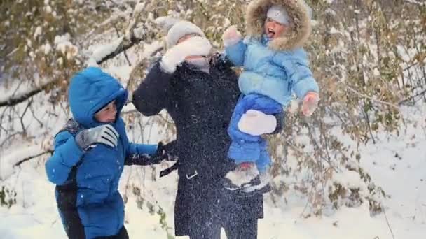 Niña y el niño lanzando nieve sobre sí mismo y disfruta de ella en el parque de invierno — Vídeos de Stock