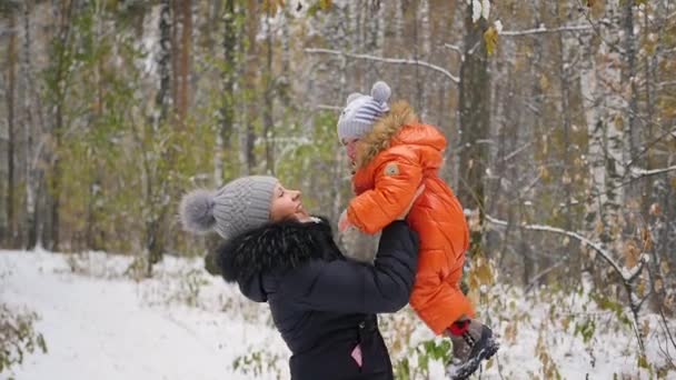 Мама играет с ребенком в зимнем парке — стоковое видео