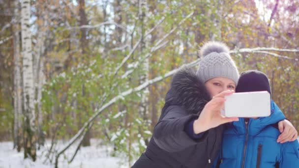 Щаслива сім'я робить селфі в зимовому парку — стокове відео