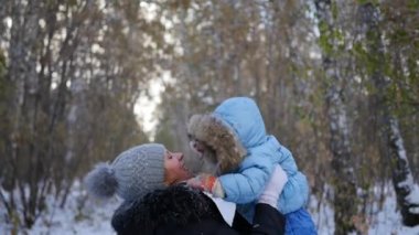 Anne ile bebek kış parkta oynarken. Anne Çocuk atar