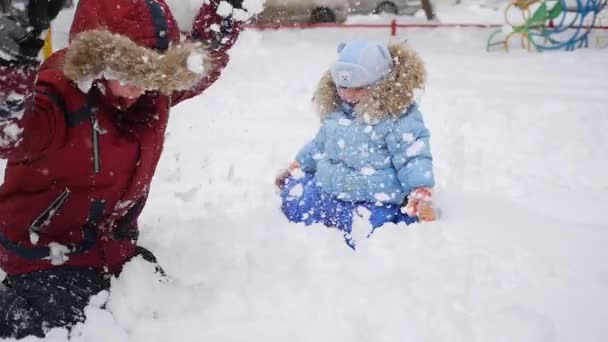Een kinderen speelt in de sneeuw — Stockvideo