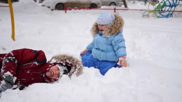 Un niño juega en la nieve — Vídeo de stock