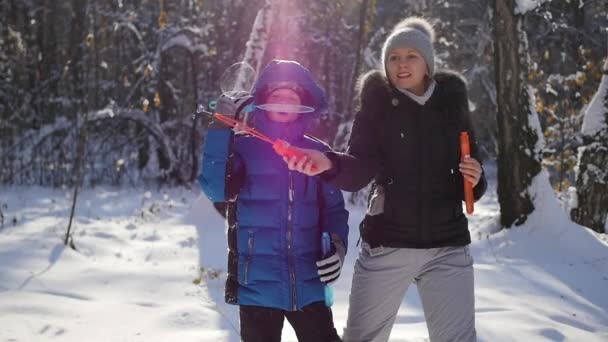 Dívka s boy úder mýdlové bubliny v destinaci winter park — Stock video
