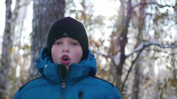 Barn gör ånga av munnen en kall solig dag — Stockvideo