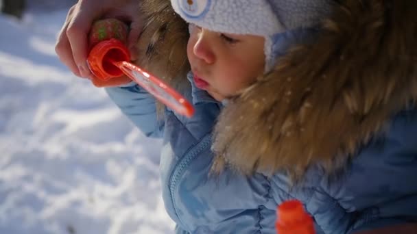 Ragazzo fa grandi bolle di sapone nel parco con gioia in una giornata soleggiata — Video Stock