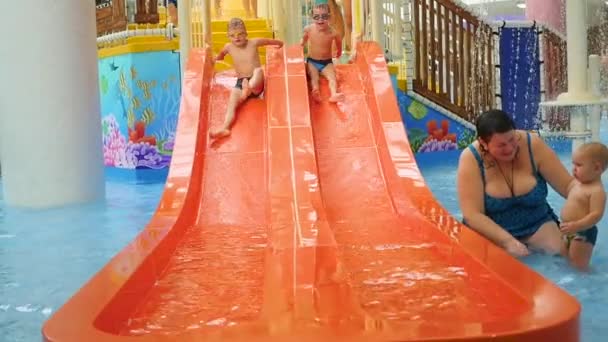 НОВОСИБИРСК, РОССИЯ - 01 ноября 2016 года: дети катаются с водной горки в аквапарке — стоковое видео